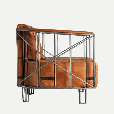 Vista lateral del Sillón en piel marrón estilo industrial Chaize, que muestra un elegante asiento de cuero marrón con un marco de metal negro y elementos de diseño geométrico modernos.
