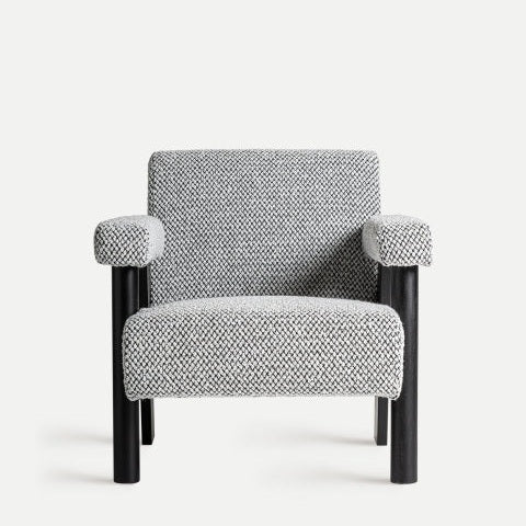 El sillón de algodón bouclé y madera Liester presenta un diseño contemporáneo con elegantes patas negras y tapizado de algodón bouclé gris, que destaca elegantemente sobre un fondo blanco liso.