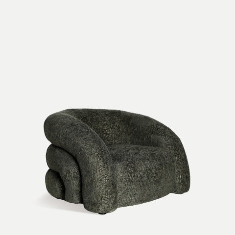El sillón tapizado verde Sournia, con tapizado de felpa verde oscuro y un diseño redondeado moderno, brinda comodidad única sobre un fondo claro.