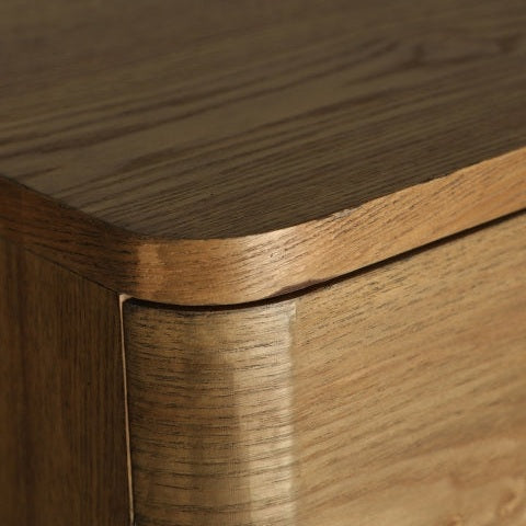 Vista de cerca de la esquina Cómoda en madera DM marrón Hoek, que presenta bordes redondeados suaves y vetas de madera visibles, resaltando su diseño contemporáneo.