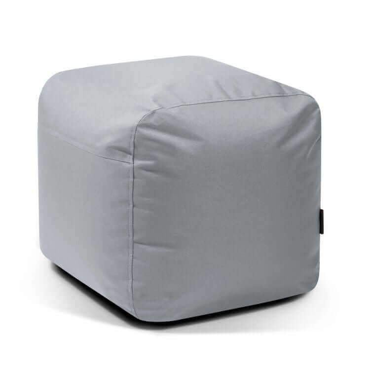 Un moderno puf cuadrado de tela impermeable brillante gris claro de 50×50×35 cm (PLUS 50 OX) con bordes redondeados ofrece un cómodo asiento, sobre fondo blanco. Adecuado para uso exterior.