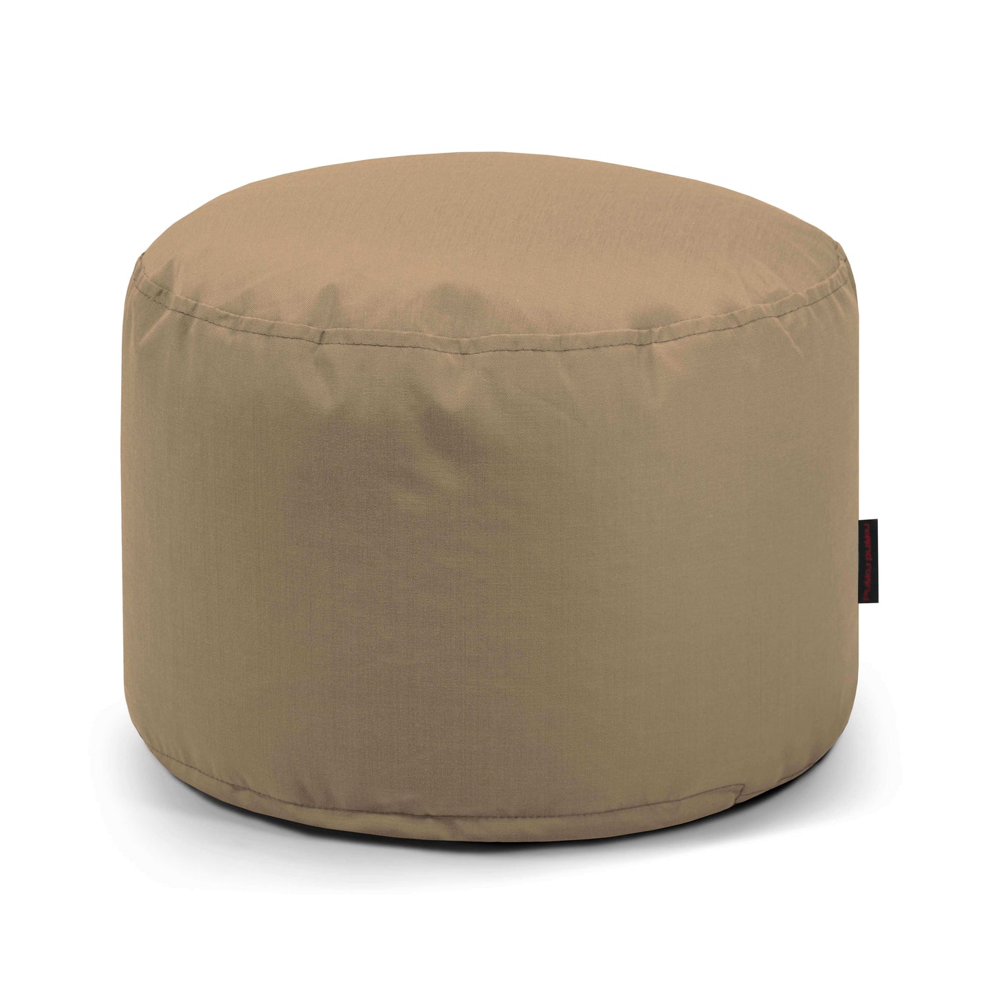 El Pouf Mini Colorin - uso exteriores es un asiento redondo, de color marrón claro, compacto y versátil, con una superficie lisa y una pequeña etiqueta de tela negra, fabricado con tejido certificado OEKO-TEX, que se muestra sobre un fondo blanco.
