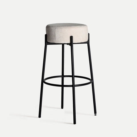 El taburete de bar Breville, de 78 cm de alto, presenta un asiento acolchado gris redondo y un marco de metal negro con cuatro patas y un reposapiés circular, incorporando una estética industrial que se alinea a la perfección con el diseño minimalista.