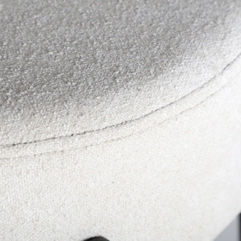 Primer plano de un cojín de asiento tapizado en color claro y texturizado con costuras visibles, que encarna el diseño minimalista del Taburete alto 78 cm en poliéster y hierro Breville.