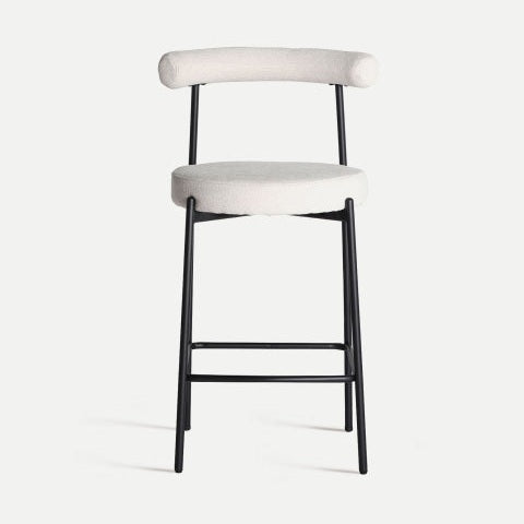 El Taburete alto 66 cm en poliéster y hierro Breville presenta un diseño moderno con un marco de metal negro y un asiento y respaldo redondos acolchados en beige, resaltando una estética contemporánea sobre un fondo claro y liso.